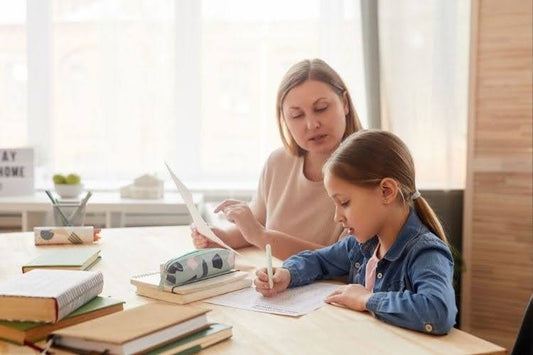 Parent helping child stay focused during a homeschool lesson.