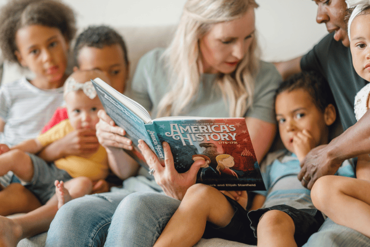 Family enjoying story time with an educational book about American history.