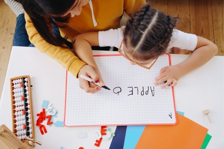 Parent teaching child during a homeschool writing lesson.