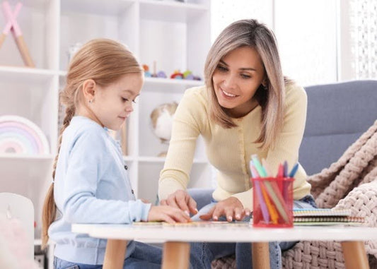 Mother helping daughter with homeschool lesson at table.